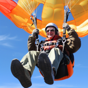 Senior parachuting down from the sky in the go-go-yearrs